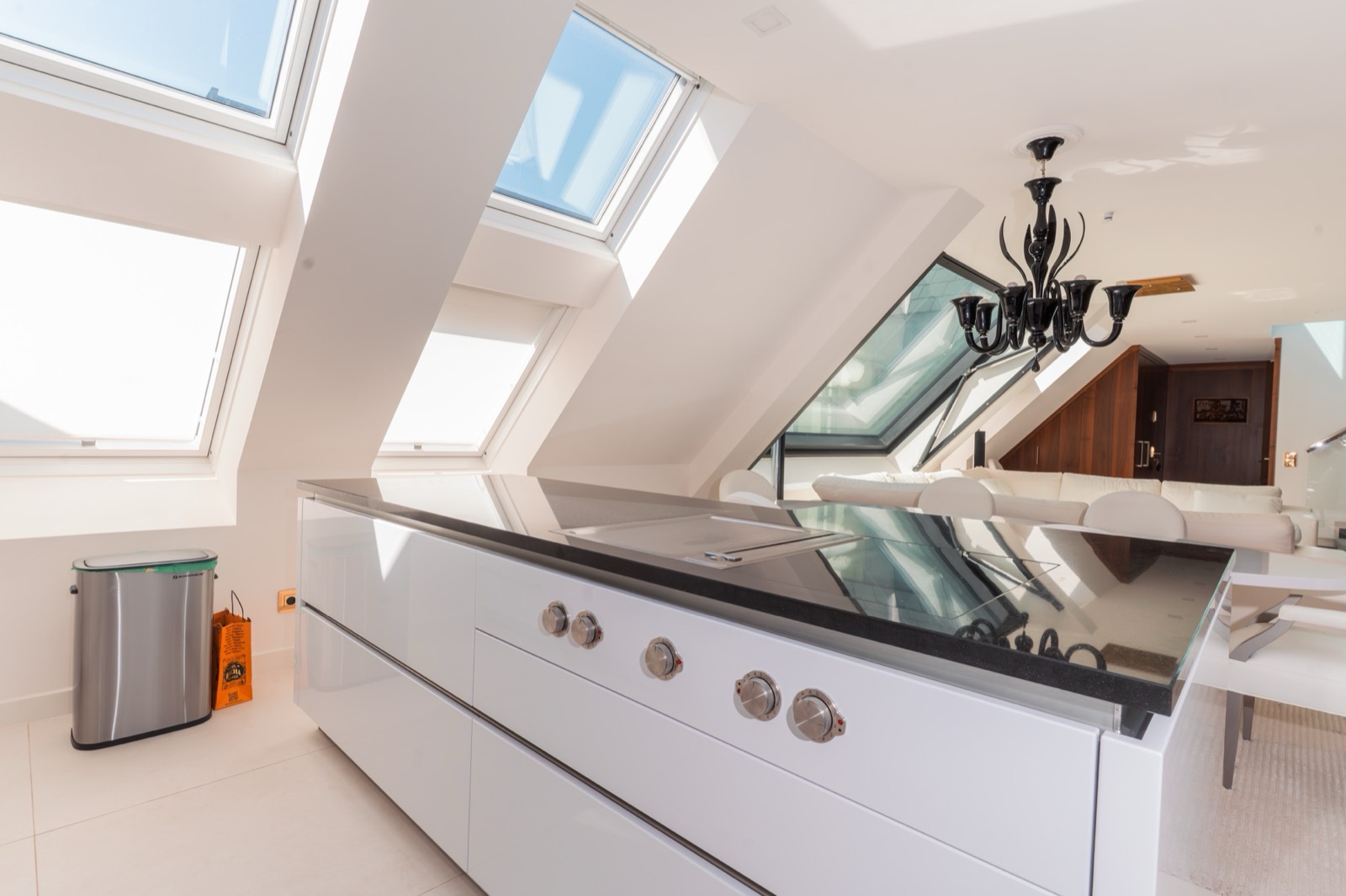 Modern penthouse kitchen with multiple skylight windows, glossy white cabinetry and dark induction hob, Vienna — Best Alex Shots interior photography