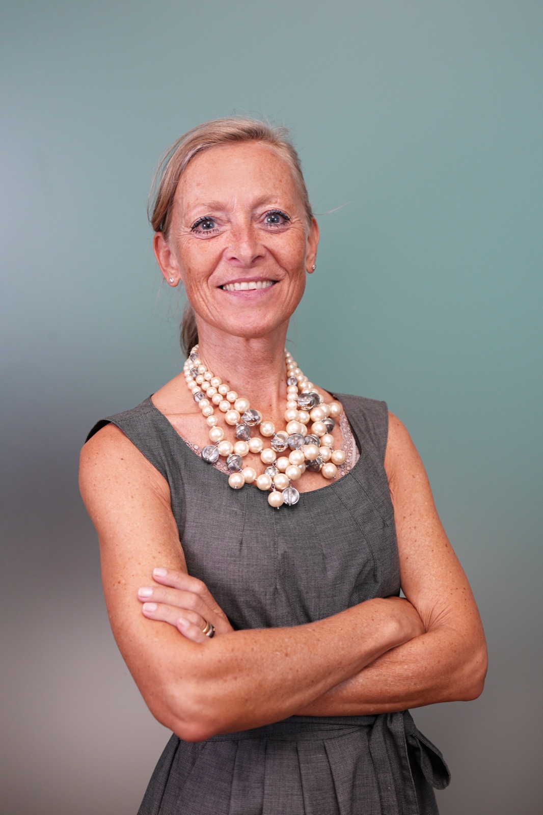 Senior female team member in grey dress with pearl necklace — studio corporate portrait by Best Alex Shots, Vienna