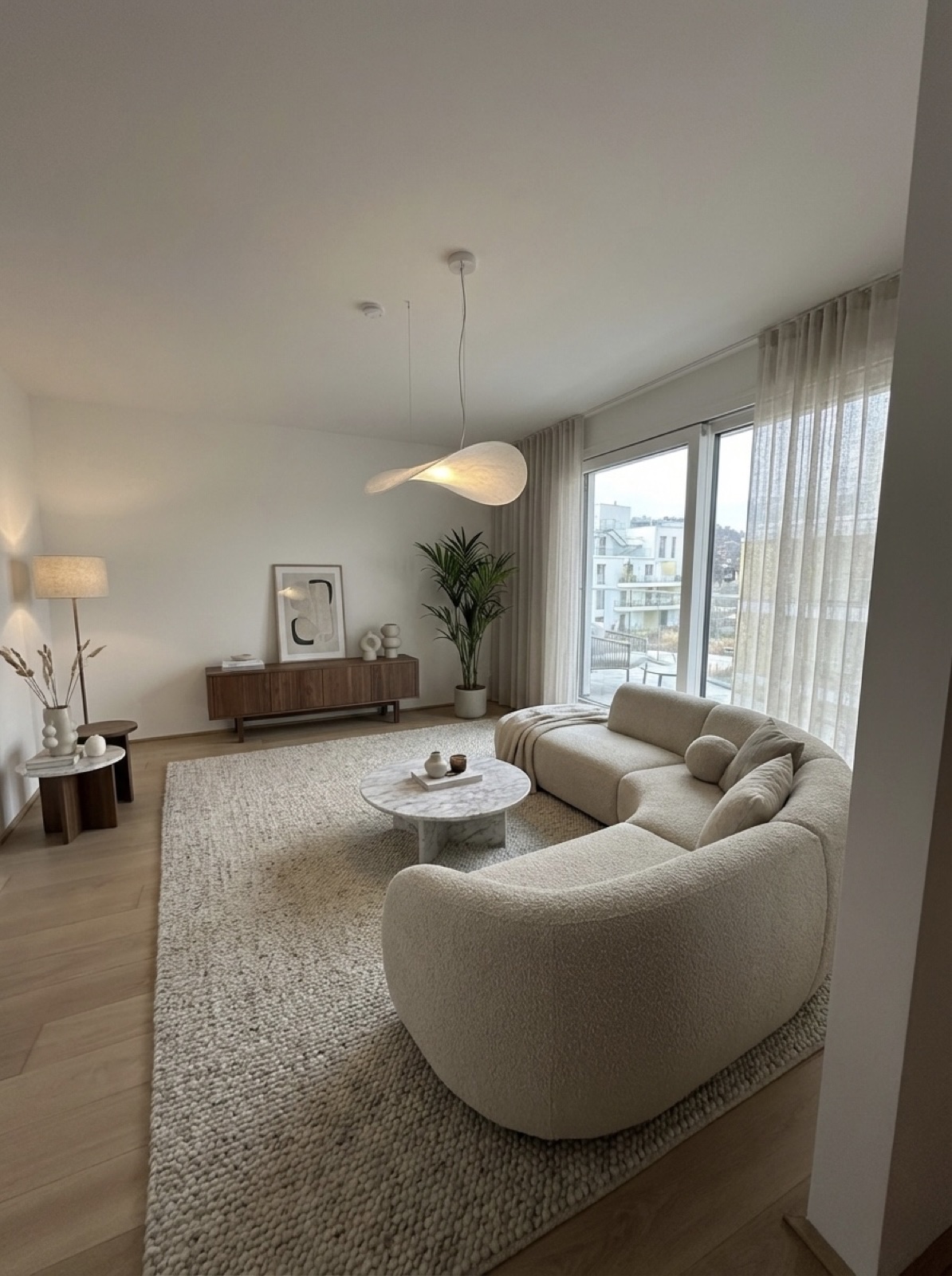 Staged living room with curved cream sofa and modern decor, Vienna — Best Alex Shots interior photography