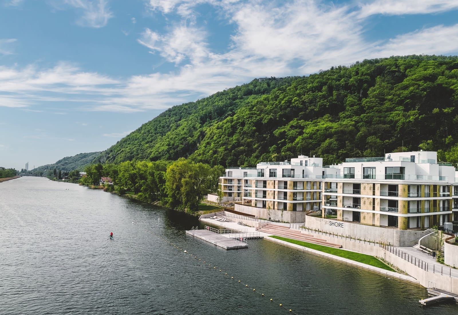High aerial drone view of The Shore complex on the green Danube riverbank in summer, Vienna — Best Alex Shots drone photography