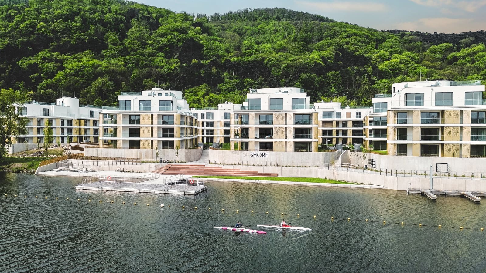 Summer drone panorama of The Shore waterfront residential complex with kayakers on the Danube, Vienna — Best Alex Shots real estate photography