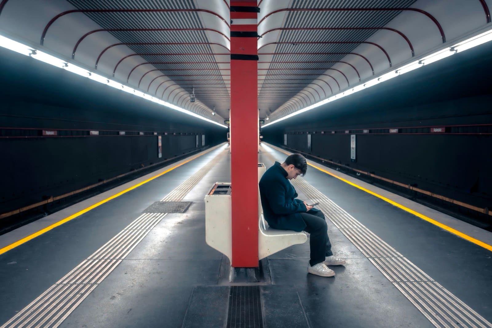 Vienna U-Bahn platform — man on a bench by the red column, symmetrical tunnel light, Best Alex Shots, Vienna