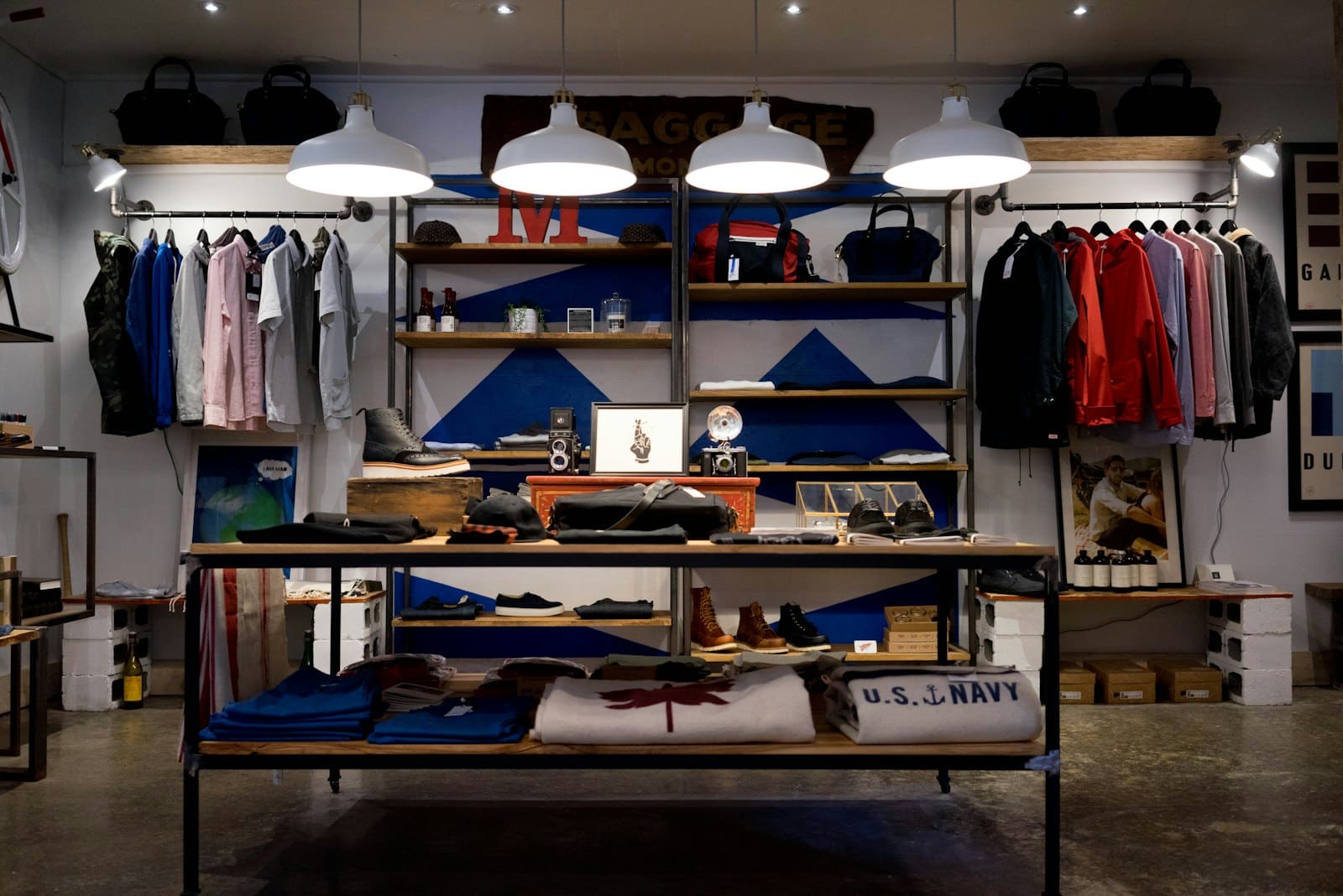 Clothing racks with jackets and shirts in coordinated colours under warm lamps